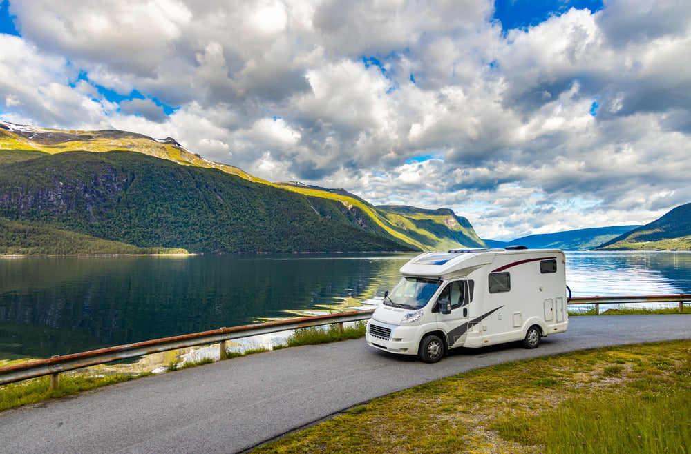 RV driving by a scenic lake
