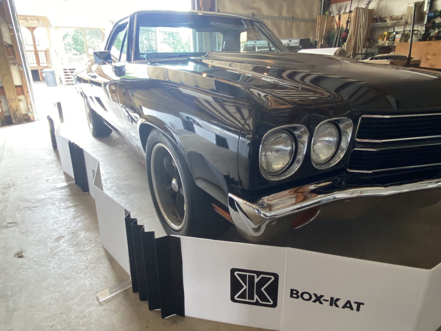 Black classic car parked inside BOX-KAT mouse barrier inside a garage