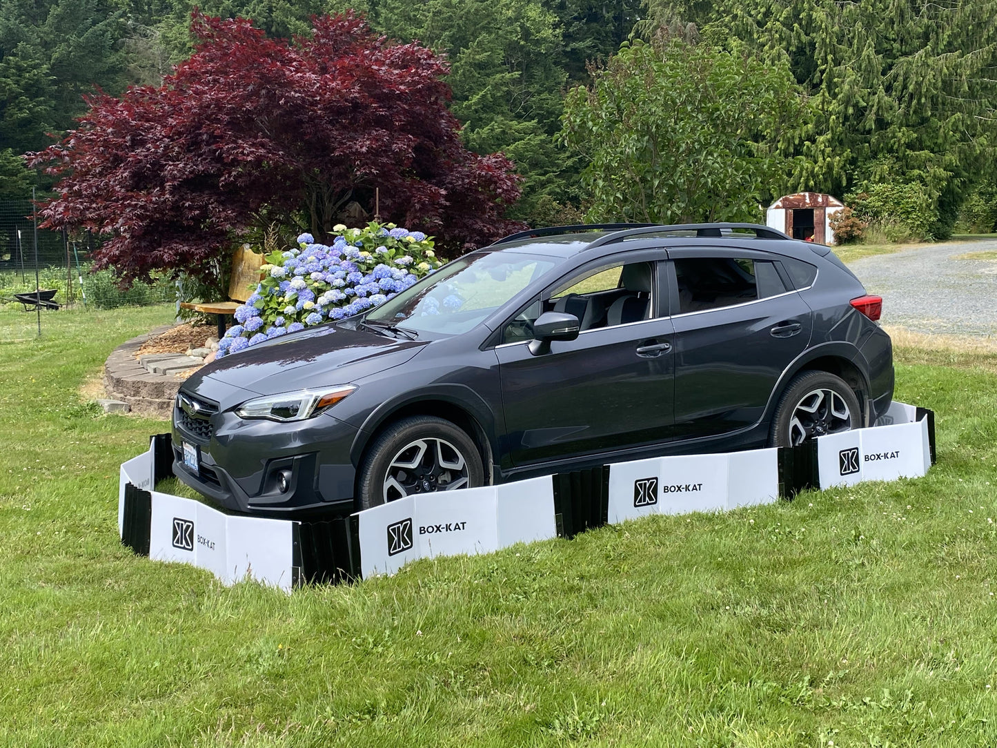 Box-Kat mouse barrier around Subaru SUV parked in grass